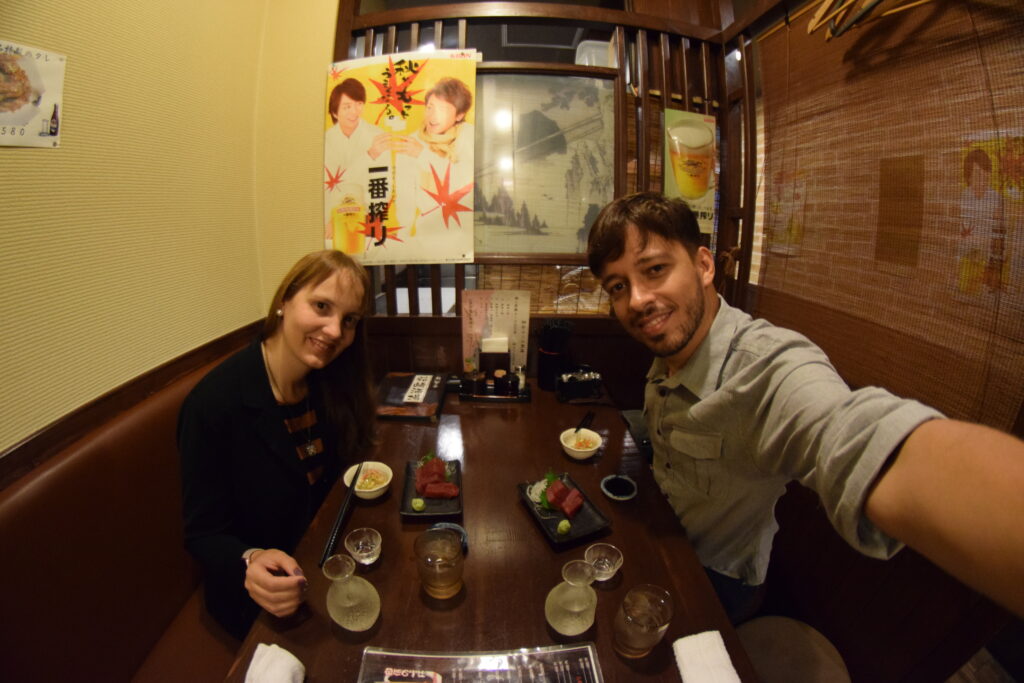 Casal sentando para jantar cedo durante a primeira viagem ao Japão, mostrando como o outono encurta os dias e influencia a rotina.